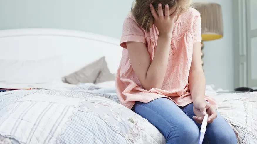 woman looking at pregnancy test