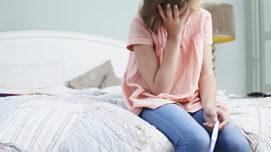 woman looking at pregnancy test