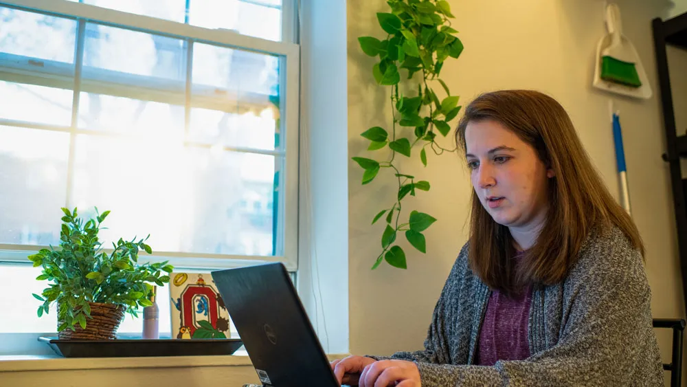 Student works on laptop in apartment