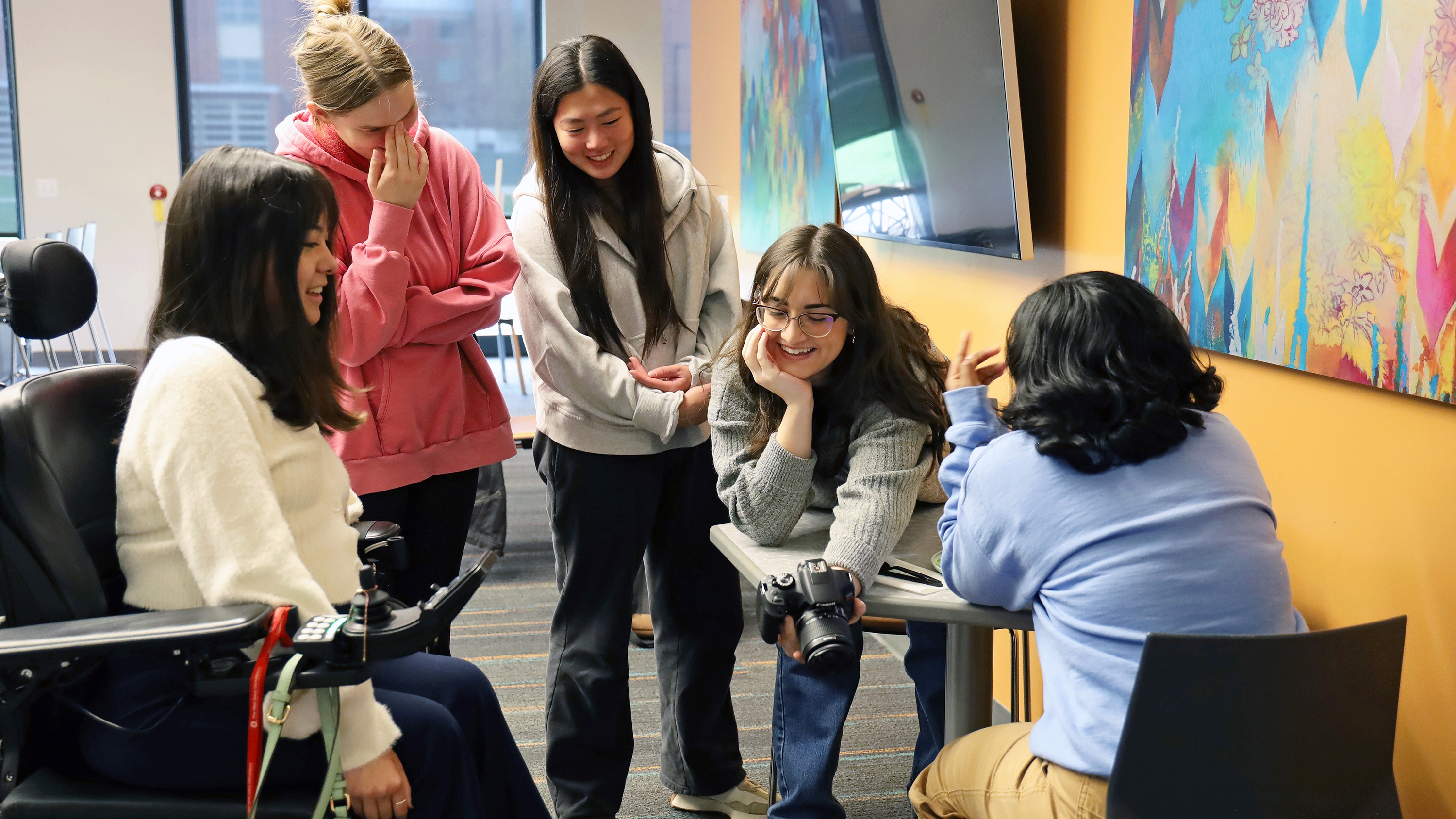 Students crowd around a camera
