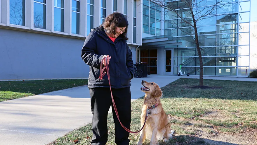 Abigail Shoben and her golden retriever Echo stand in front of Cunz hall