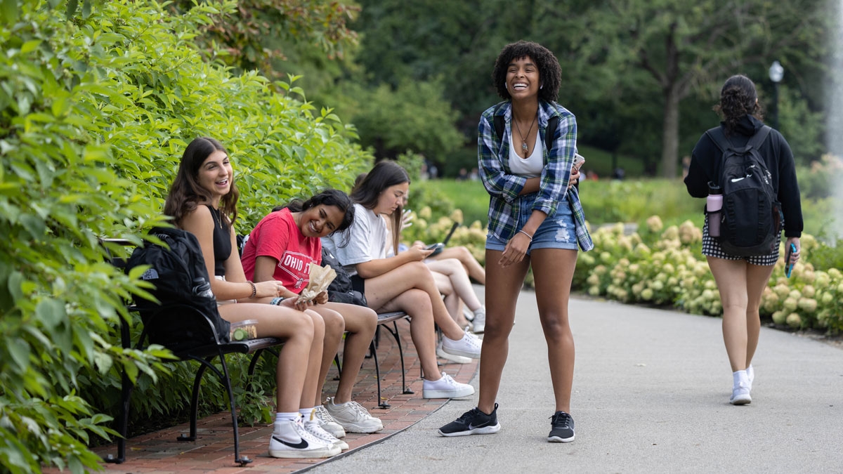 Students react with laughter while talking at Mirror Lake 