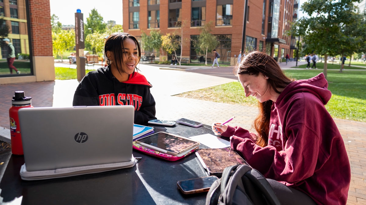 Two students studying at a table outside on Ohio State's Columbus campus