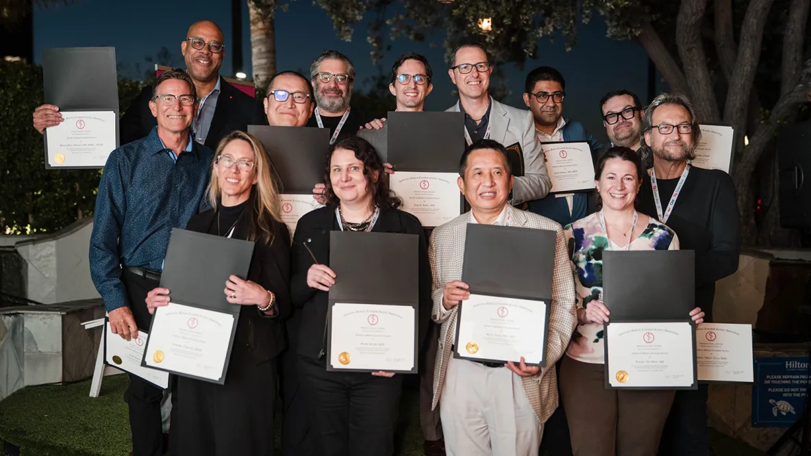 a group of people hold certificates.