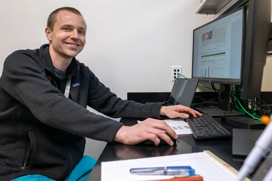 A biostats students works on research at his computer