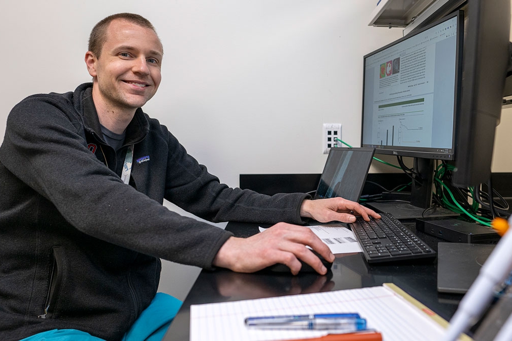 A biostats students works on research at his computer