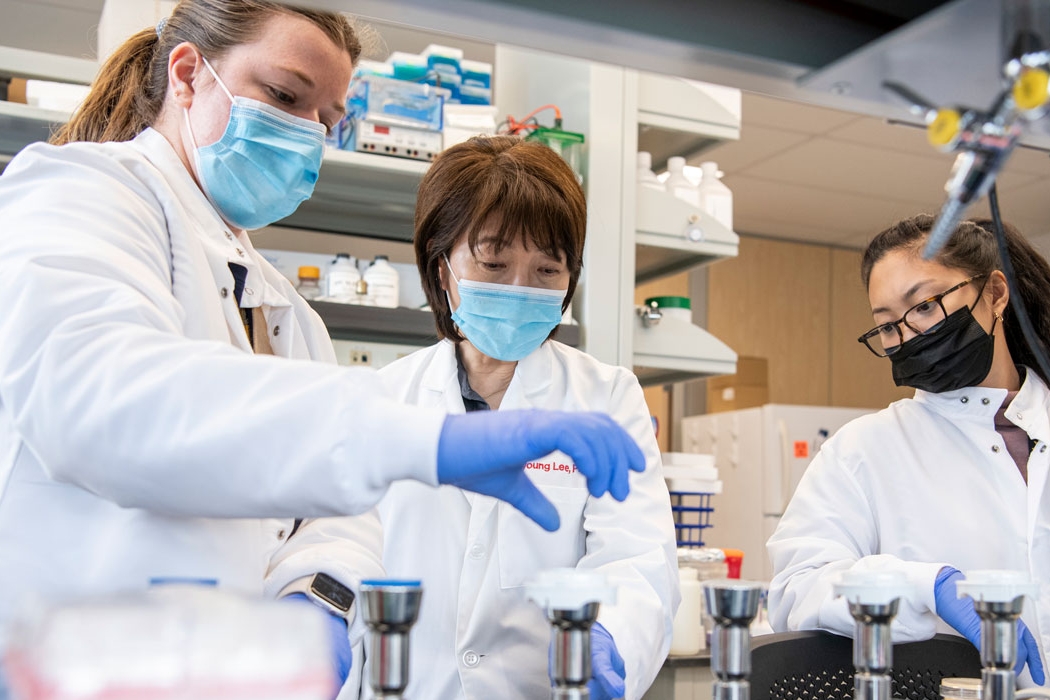 Professor and two student researchers test water samples in CPH wet lab