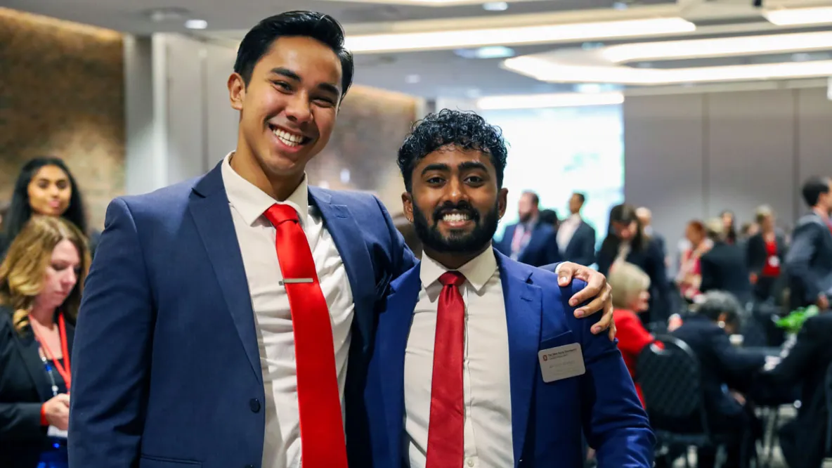 Two Master of Health Administration students in blue suits and red ties