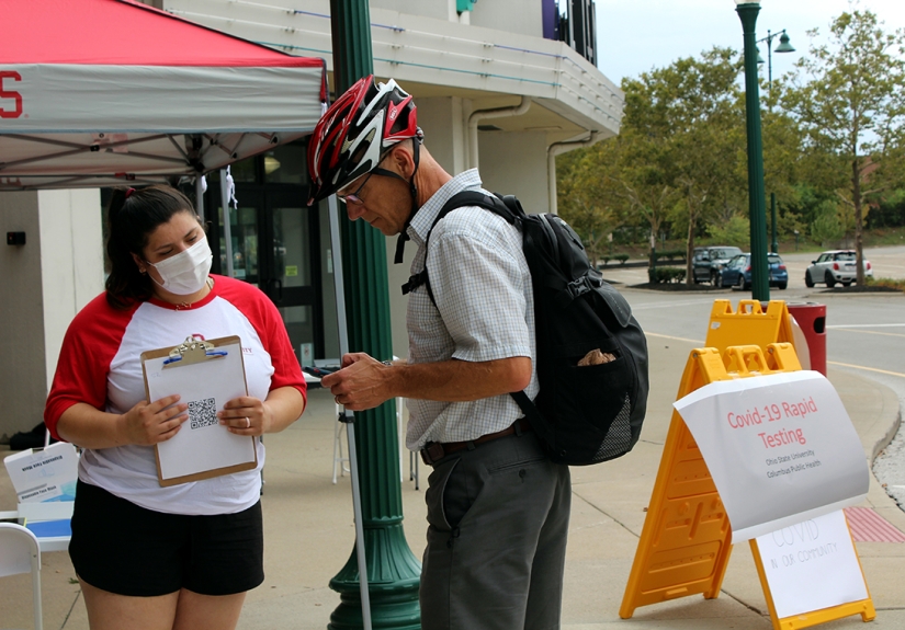 Fourth-year public health student Lauren Putz helps check in a community member for a COVID-19 test