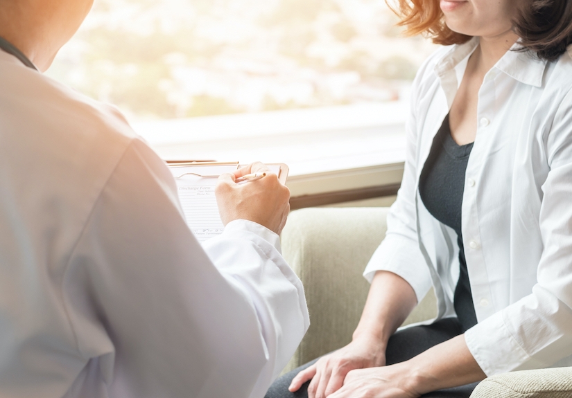 woman speaking with medical staff