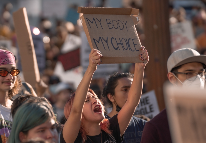 Woman in crowd holding "my body my choice" sign