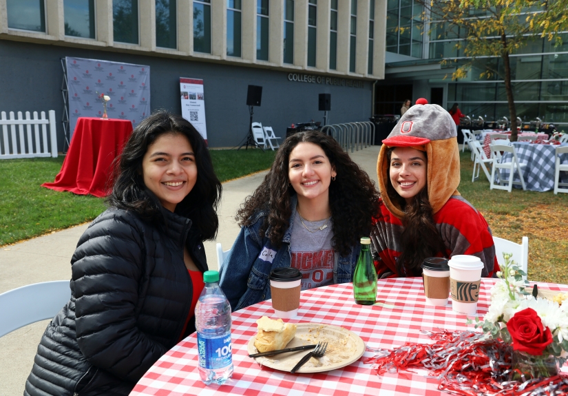 three students pose for a photo during the Homecoming tailgate.