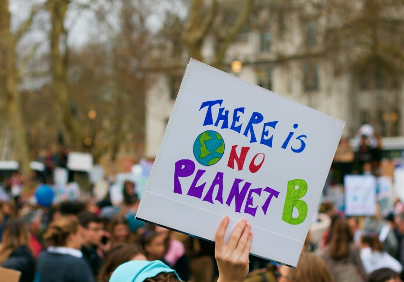 A demonstrator at an environmental rally holds a sign that says "No Planet B"