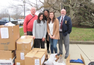 Students Hannah Piscalko (front left) and Elli Schwartz (front right), with epidemiology research associate Deborah Jones (back center), delivering winter clothing to officials in Scioto County.