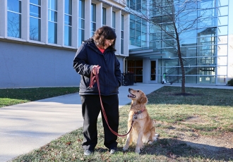 Abigail Shoben and her golden retriever Echo stand in front of Cunz hall
