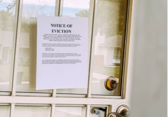 A door with an eviction notice taped to it.