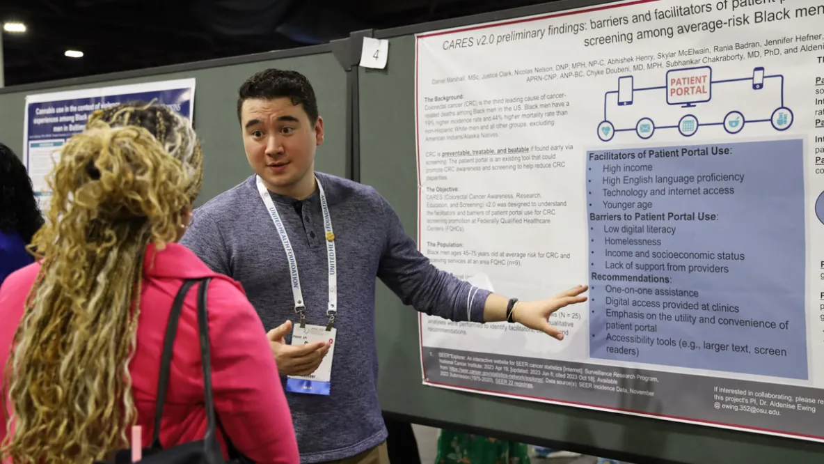 Student sharing research results at poster presentation